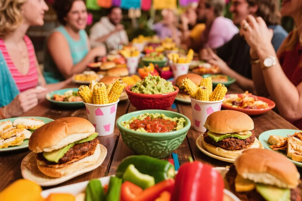 球迷聚会的融合菜单摆盘：迷你汉堡拼盘、墨西哥玉米杯、牛油果酱与莎莎的双蘸酱